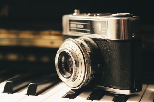 close-up-of-vintage-camera-on-piano-keys